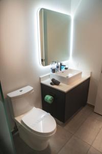 La salle de bains est pourvue de toilettes, d'un lavabo et d'un miroir. dans l'établissement Miami High Town View 1610, à Miami