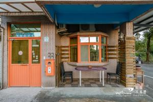 a building with a table and chairs outside of it at New Fox Guest House in Zhuangwei