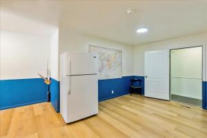 ein leeres Zimmer mit einem weißen Kühlschrank und blauen Wänden in der Unterkunft Private Bedroom Quiet Neighborhood in Ogden