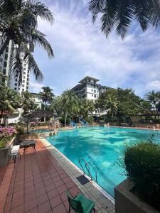 duży basen z palmami i budynek w obiekcie AizatAzmi Homestay w Malakce