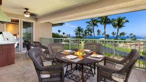 a patio with a table and chairs with a view of the ocean at OCEAN PALSM VILLA Refined 3BR Waiulaula Home with Stunning Ocean Views in Hapuna Beach