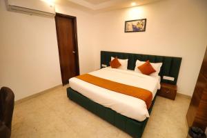 a bedroom with a large bed with orange pillows at Sandhu Lodge in Jamnagar