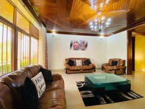 a living room with a leather couch and a table at Quiet and Spacious Hidden Gem in Kigali with Breathtaking Views right by the Airport in Kigali