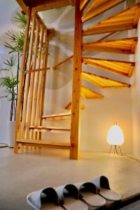 une chambre avec des escaliers et une table avec une lampe dans l'établissement Hotel Little Swiss House, à Motobu