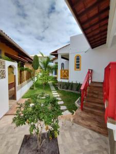 a house with a dog standing in the yard at Residencial Olinda de Boipeba in Ilha de Boipeba