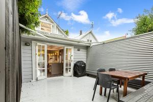 a patio with a wooden table and chairs at Beautiful Ponsonby Villa by Zodiak Stays in Auckland