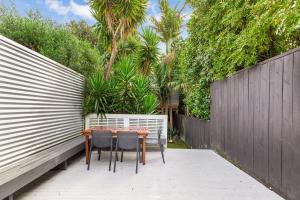 uma mesa e cadeiras num pátio com uma cerca em Beautiful Ponsonby Villa em Auckland