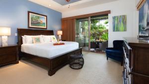 ワイコロアにあるTHE OASIS AT KULALANI Lovely 3BR Oasis in Kulalani Closest to Pool Complexのベッドと椅子と窓のある寝室 +38枚の写真