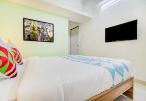1 dormitorio con 1 cama y TV de pantalla plana en OYO Dhage's Homestay, en Pune