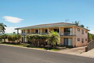 a house with palm trees on the side of the road at Pacific Palms 4 Unit 4, 9-11 Terrace St Evans Head in Evans Head