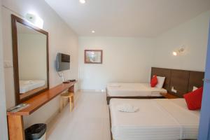 a hotel room with two beds and a mirror at Kallapangha Resort Khlongwan in Klong Wan