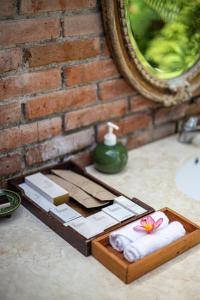 - un plateau en bois avec des serviettes et un miroir sur un comptoir dans l'établissement Villa Canggu by Plataran, à Canggu