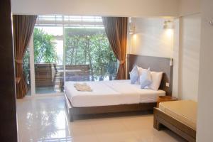 a bedroom with a bed and a large window at Kallapangha Resort Khlongwan in Klong Wan