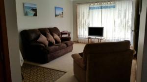 sala de estar con sofá y TV en The Sea Ranch 1 Unit 1, 45 Beech Street Evans Head en Evans Head