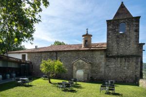 an old stone church with tables and chairs in the yard at Hotel Conventual Sierra de Gata in San Martín de Trevejo