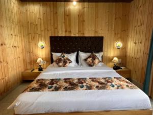ラージコートにあるBhupesh Lodgeの木製の壁のベッドルーム1室(大型ベッド1台付)