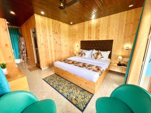 um quarto com uma cama grande num quarto com paredes de madeira em Bhupesh Lodge em Rajkot