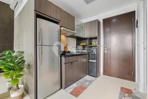 une cuisine avec des armoires en bois et un réfrigérateur dans l'établissement Finis by Kozystay - Grogol, à Jakarta