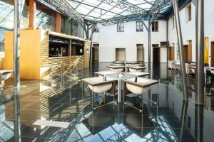 una cafetería con mesas y sillas en un edificio en Hospedería Conventual Sierra de Gata, en San Martín de Trevejo