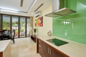 a kitchen with a green counter top and a table at Ocean Sunny Villas Da Nang in Danang