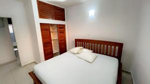 a bedroom with a bed with white sheets and pillows at Studio ovangi bis in Libreville