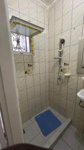 a shower with a blue mat in a bathroom at Studio ovangi bis in Libreville