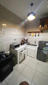 a kitchen with a stove and a sink and a refrigerator at Studio ovangi bis in Libreville