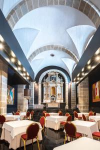 a dining room with tables and chairs and a church at Hospedería Conventual Sierra de Gata in San Martín de Trevejo