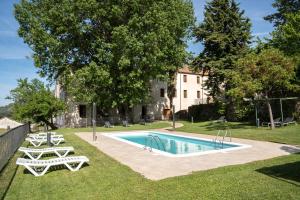 einen Pool mit zwei Liegestühlen und ein Haus in der Unterkunft Hospedería Conventual Sierra de Gata in San Martín de Trevejo