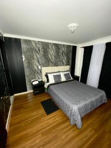 a bedroom with a bed and a stone wall at Hotel Canela 96 in Bogotá