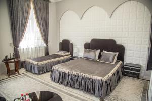 duas camas num quarto com duas janelas em Hayat Samarkand em Samarkand