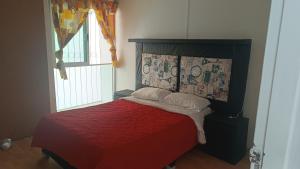 ein Schlafzimmer mit einem Bett mit einer roten Decke und einem Fenster in der Unterkunft Las flores Boulevard in Mexiko-Stadt