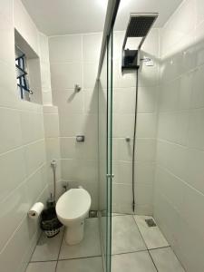 La salle de bains est pourvue de toilettes et d'une douche en verre. dans l'établissement VA Apart Hotel Savassi, à Divinópolis