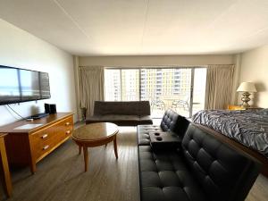 a hotel room with a bed and a couch at Ilikai Apt 1042 - Spacious Studio with Ocean-Lagoon Views in Honolulu