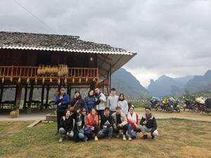 Làng Cac的住宿－Du Già Coffee View Homestay，一群人站在一座建筑物前摆着一张照片