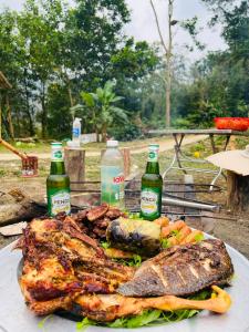 a plate of food with meat and two bottles of beer at Du Già Coffee View Homestay in Làng Cac