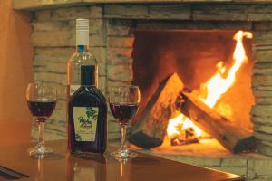 two glasses of red wine next to a fireplace at Hospedaje Cabaña Familiar in Otavalo +38 photos