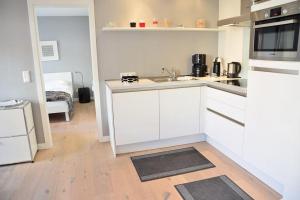 uma cozinha branca com um lavatório e um fogão em Bomhoffstr. 22a, W4, Blue Water em Westerland