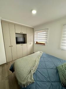 ein Schlafzimmer mit einem Bett und einem TV. in der Unterkunft Cálido y espacioso departamento in Los Ángeles