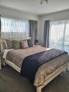 1 dormitorio con 1 cama grande y ventanas en The Dolls House, en Rotorua
