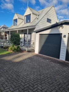 una casa con dos puertas de garaje y un camino de entrada en The Dolls House, en Rotorua