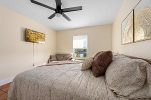 um quarto com uma cama e uma ventoinha de tecto em CapeCoral Waterfront Villa - Heated Pool & Jacuzzi em Cape Coral