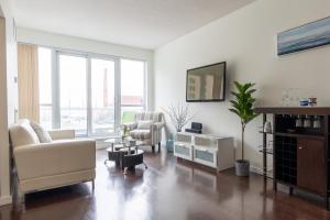 a living room with white furniture and large windows at Harbour Front Luxury Condo 2 Bed 2 Bath in Toronto