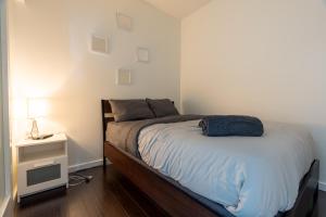 a bedroom with a bed and a night stand with a lamp at Harbour Front Luxury Condo 2 Bed 2 Bath in Toronto