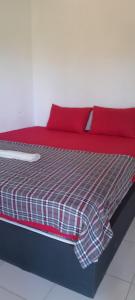 a bed with red sheets and red pillows at Romantic Homestay in Kuta Lombok