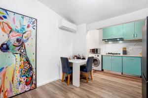a kitchen with a table and a painting of a woman at Prime Modern Brilliance with Prahran Convenience in Melbourne