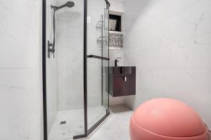 a bathroom with a glass shower with a pink stool at Prime Modern Brilliance with Prahran Convenience in Melbourne