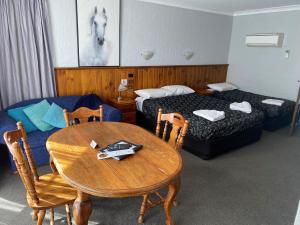 a hotel room with a table and a bed and a desk at Corryong County Inn in Corryong