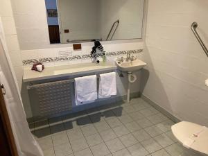 a bathroom with a sink and a toilet and a mirror at Corryong County Inn in Corryong