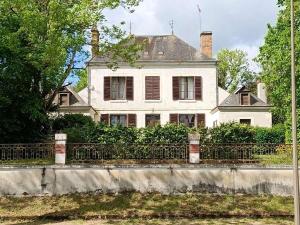 uma velha casa branca com uma cerca à frente. em VILLA ESPERANZA Suite de 2 à 4 personnes proche Zoo de Beauval et châteaux de La Loire em Valençay